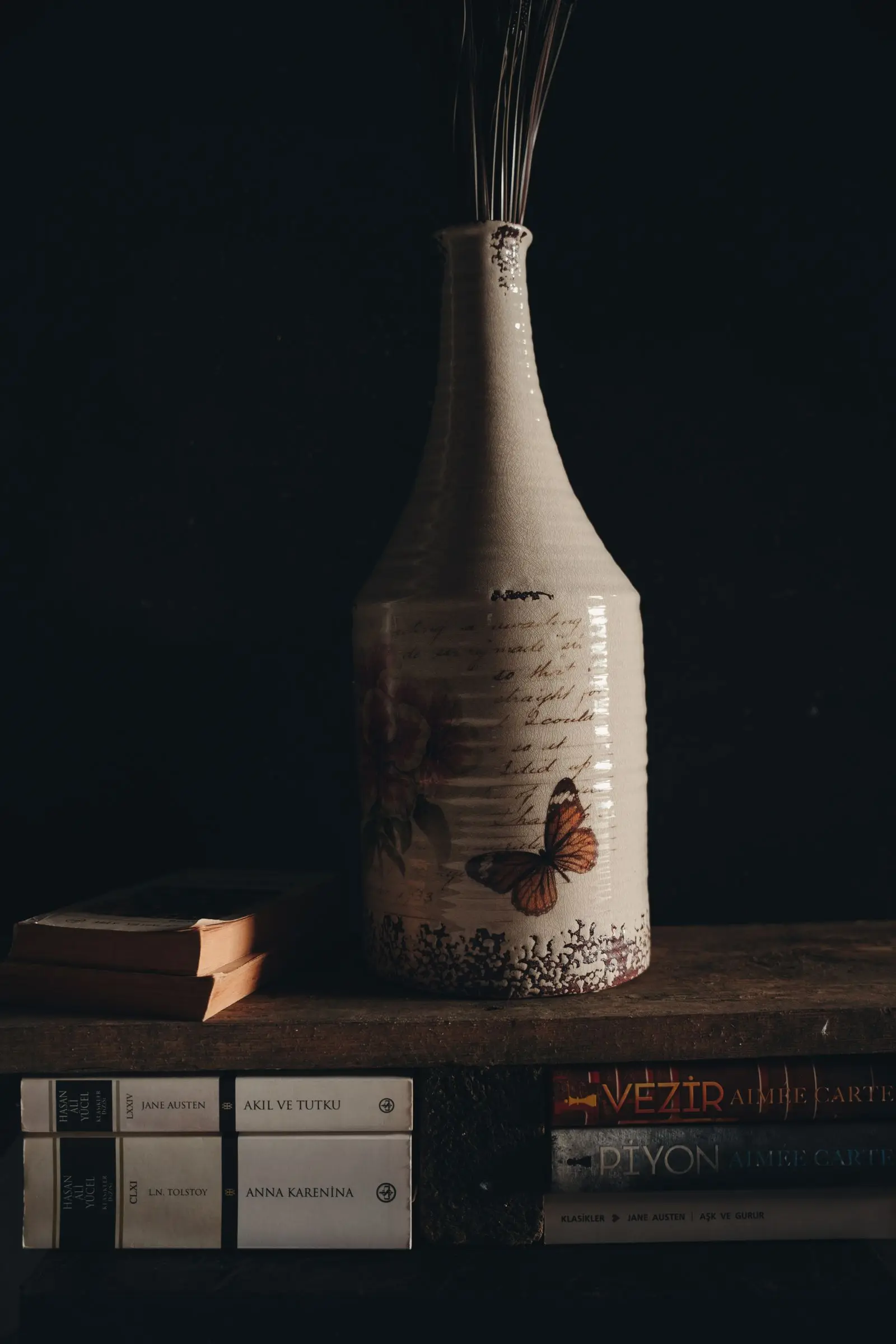 Vase décoratif en céramique entouré de livres anciens